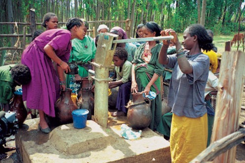 African villagers pump water from a well.